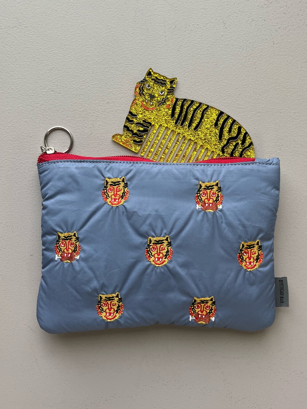 ブラック系のスマホグッズ、ゴールド系のパスケース、ピンク系の香水を着用したレディースの冬コーディネートの5枚目の写真