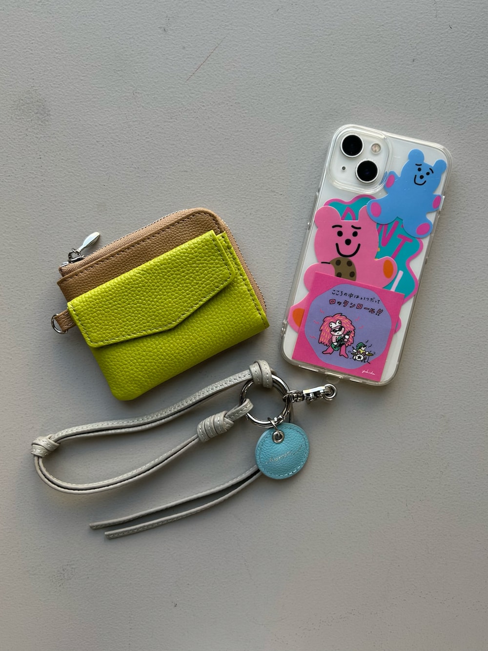 グレー系のスマホグッズ、ベージュ系の財布、グレー系のポーチを着用したレディースの春コーディネートの2枚目の写真