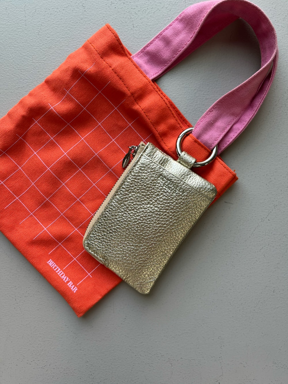 ゴールド系のパスケース、ホワイト系のチャーム、その他の香水を着用したレディースの夏コーディネートの3枚目の写真