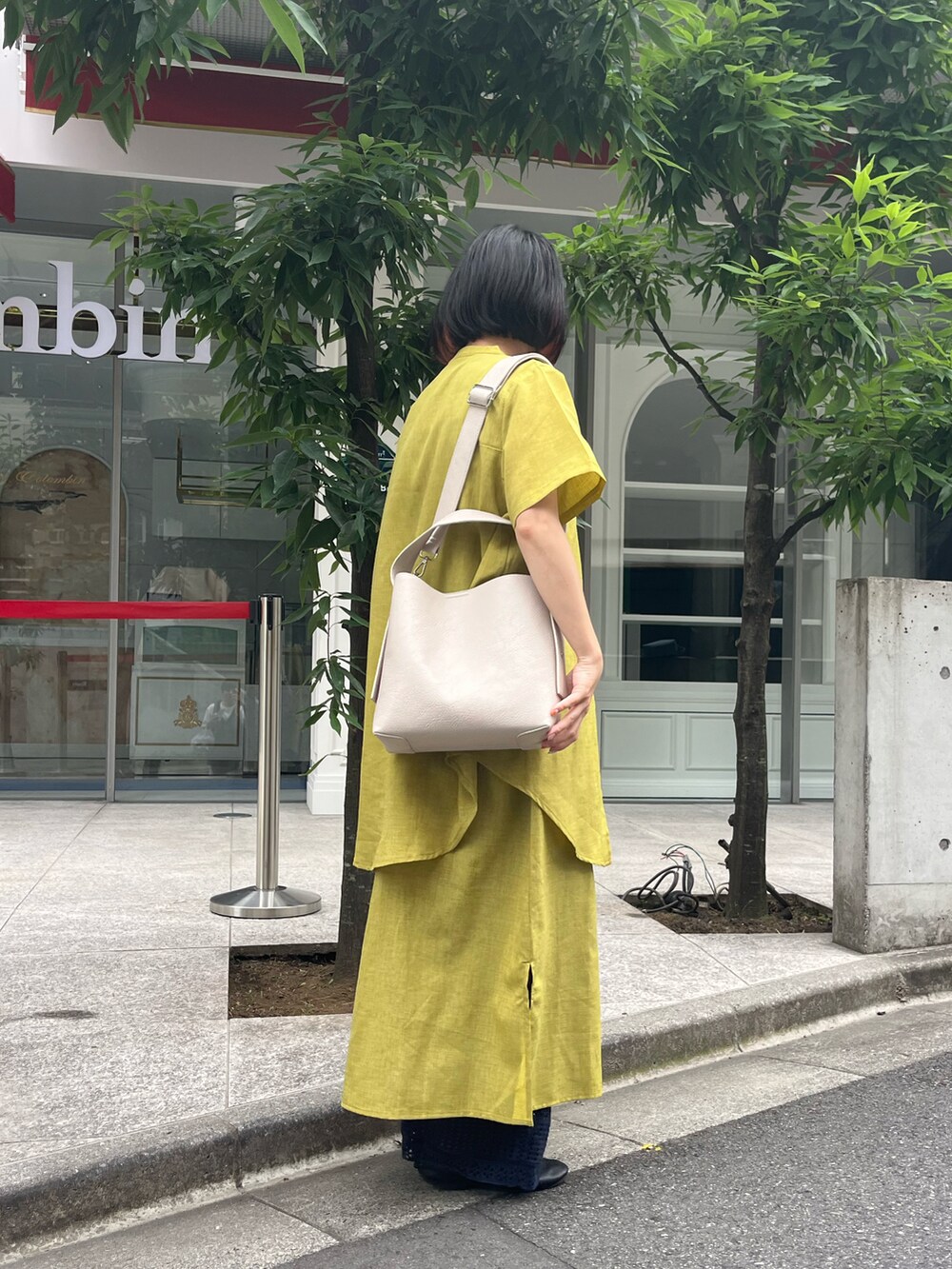 ブラック系のドレスシューズ、ホワイト系のショルダーバッグ、イエロー系のワンピース/ドレスを着用したレディースの夏コーディネートの3枚目の写真