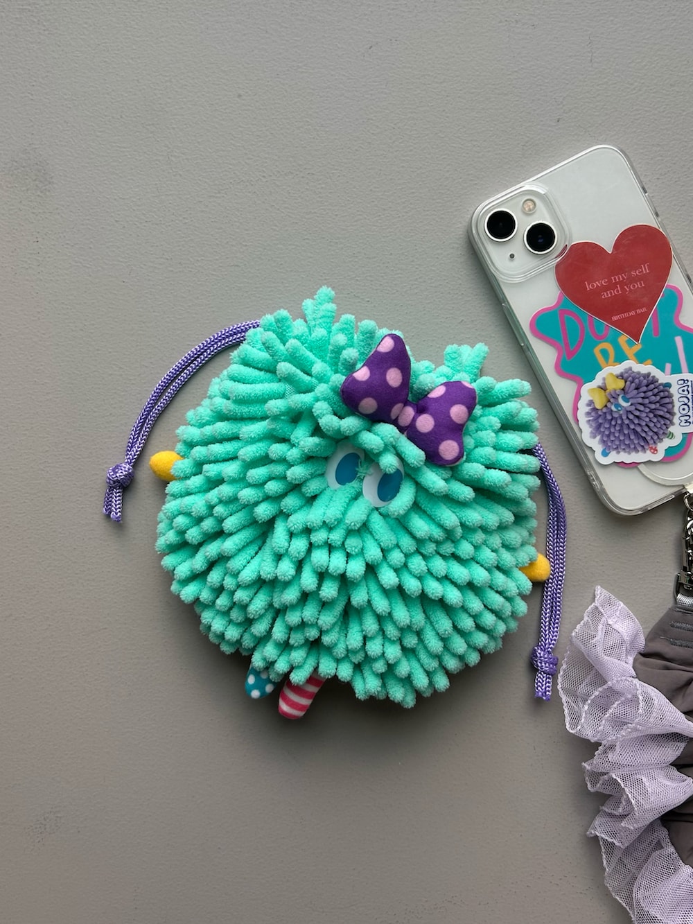 グリーン系のポーチ、シルバー系の財布、グレー系のポーチを着用したレディースの秋コーディネートの2枚目の写真