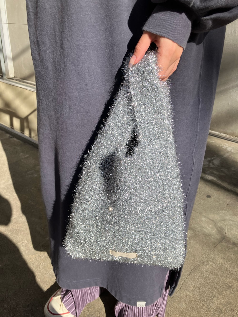 シルバー系のトートバッグ、ブルー系のワンピース、パープル系のパンツを着用したレディースの秋コーディネートの2枚目の写真