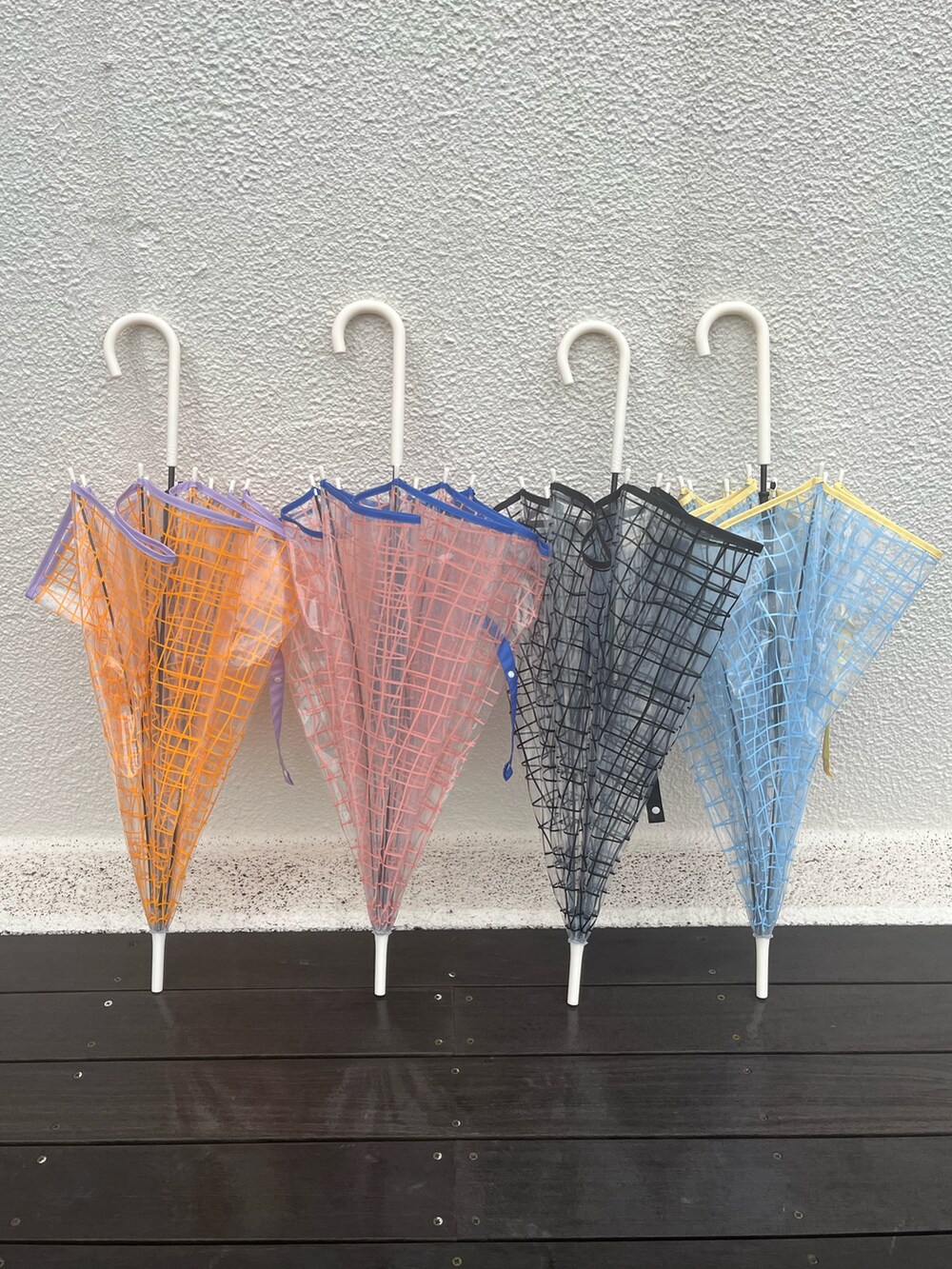 ブラック系のドレスシューズ、ホワイト系のその他パンツ、オレンジ系の長傘を着用したレディースの春コーディネートの2枚目の写真