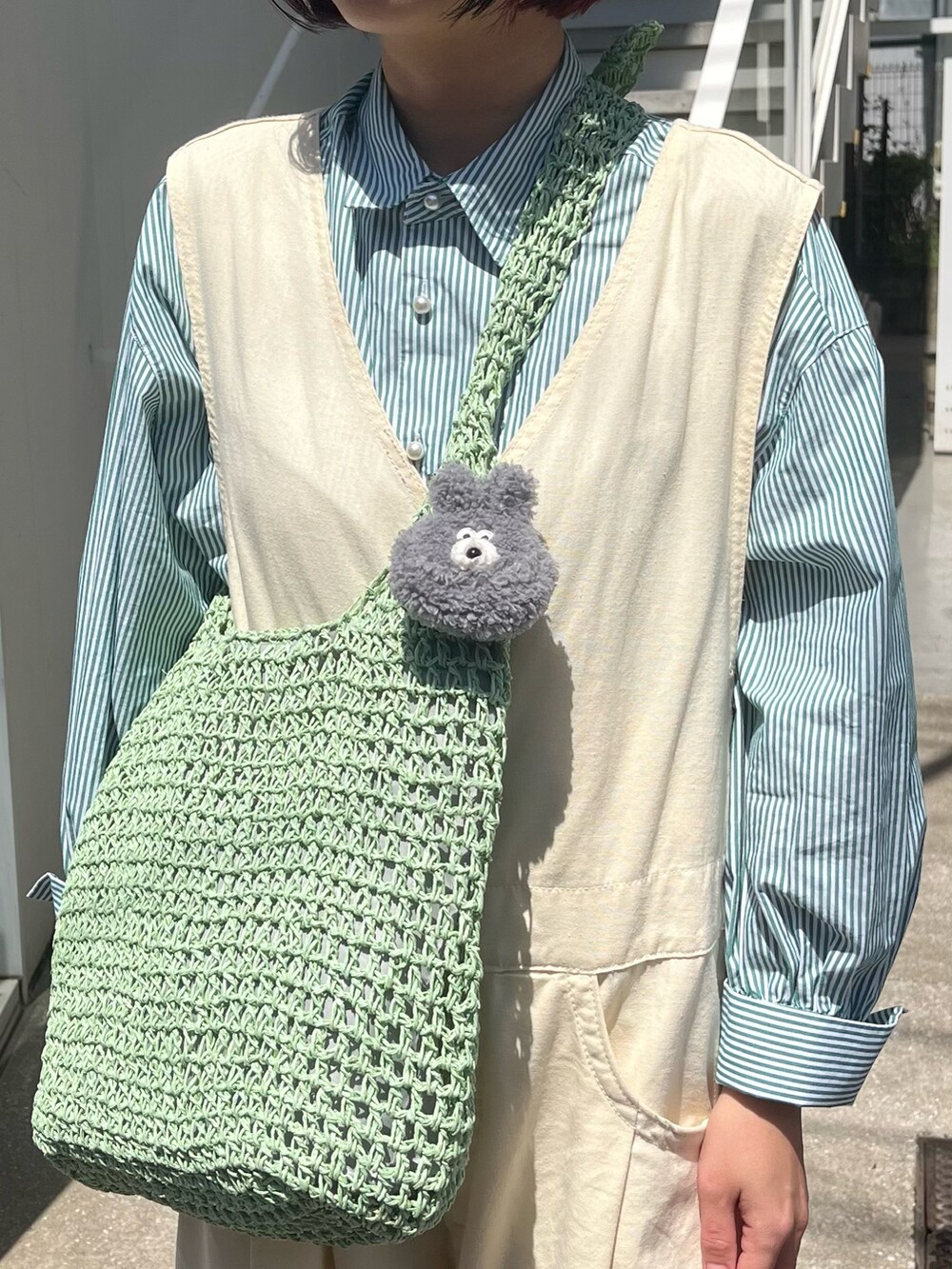 グリーン系のショルダーバッグ、グリーン系のシャツ/ブラウス、グレー系のヘッドフォン/イヤホンを着用したレディースの春コーディネートの3枚目の写真