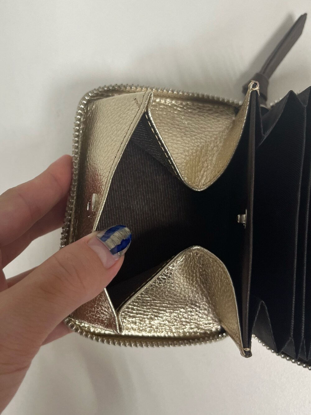 グレー系のトートバッグ、ブラック系の財布、ブラック系のハットを着用したレディースの夏コーディネートの4枚目の写真