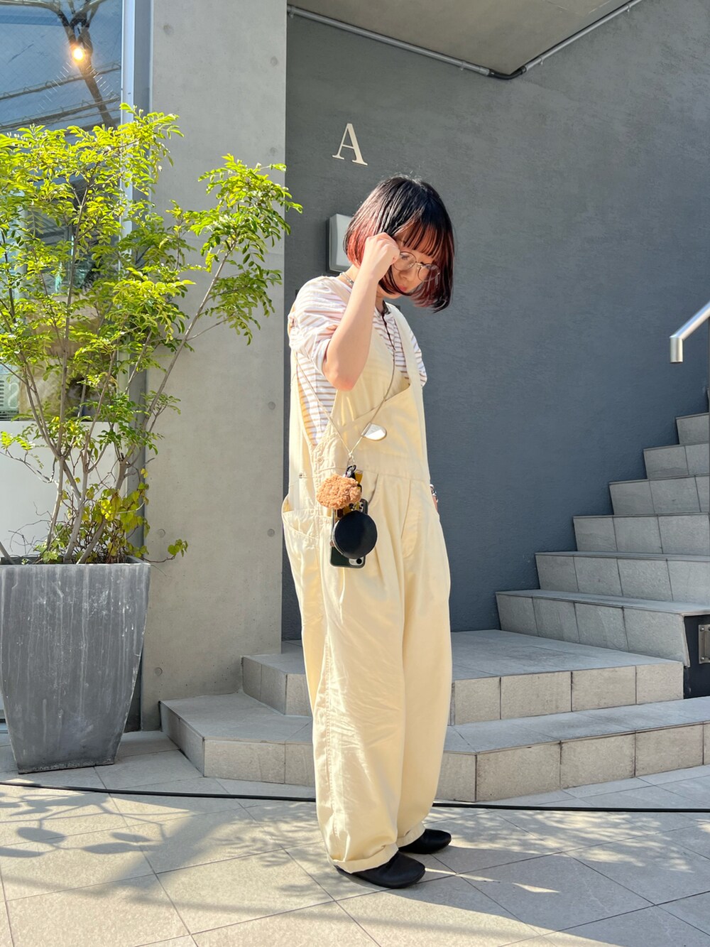 ブラック系のドレスシューズ、グリーン系のスマホケース/カバー、ブラック系のコインケースを着用したレディースの夏コーディネートの2枚目の写真