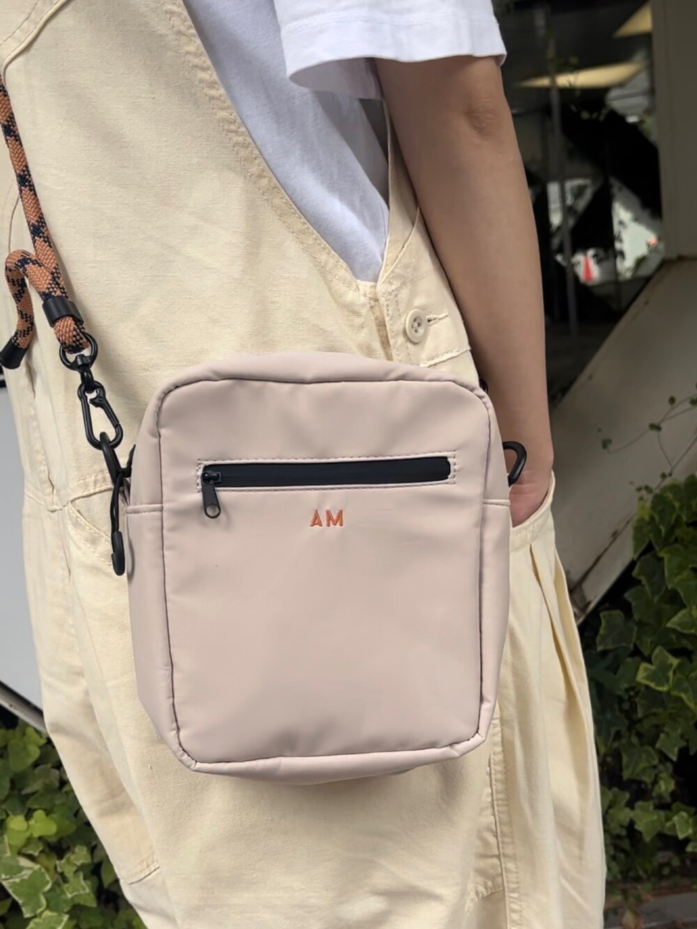 ベージュ系のショルダーバッグ、ベージュ系のスニーカー、ベージュ系のサロペット/オーバーオールを着用したレディースの夏コーディネートの3枚目の写真