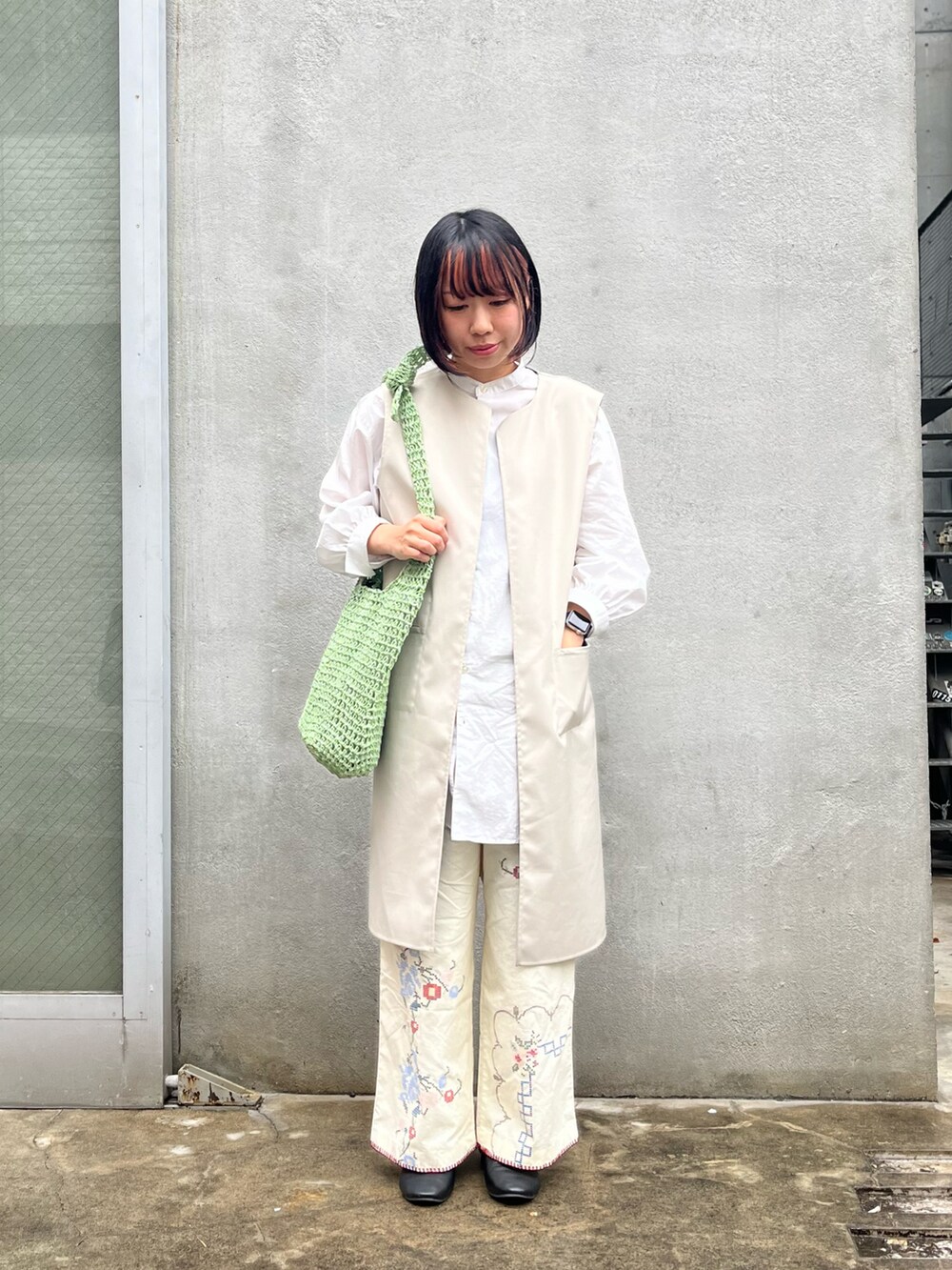ブラック系のドレスシューズ、グリーン系のショルダーバッグ、ホワイト系のその他パンツを着用したレディースの春コーディネートの2枚目の写真