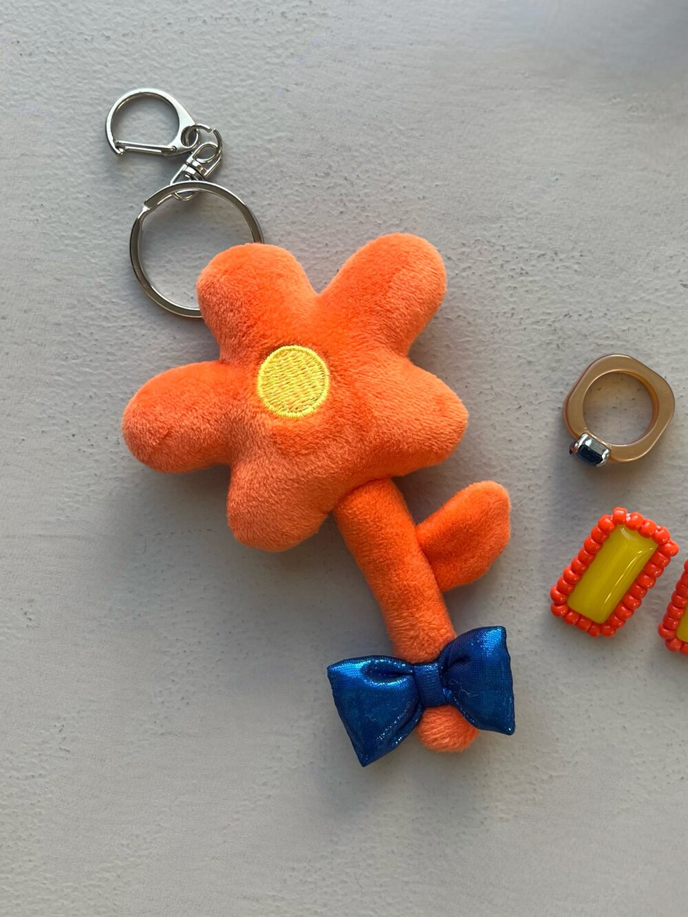 オレンジ系のキーホルダー、ベージュ系の財布、ピンク系のヘアオイル/ヘアミルクを着用したレディースの春コーディネートの5枚目の写真