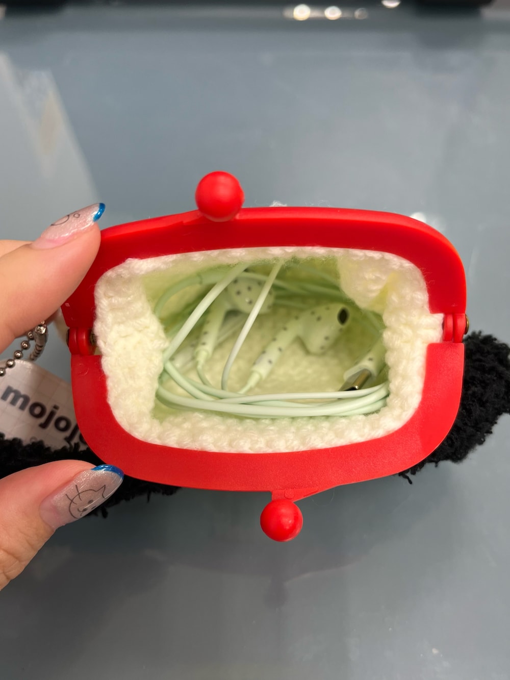 イエロー系のキーケース/キーアクセサリー、ホワイト系のポーチ、グリーン系のステーショナリーを着用したレディースの夏コーディネートの2枚目の写真
