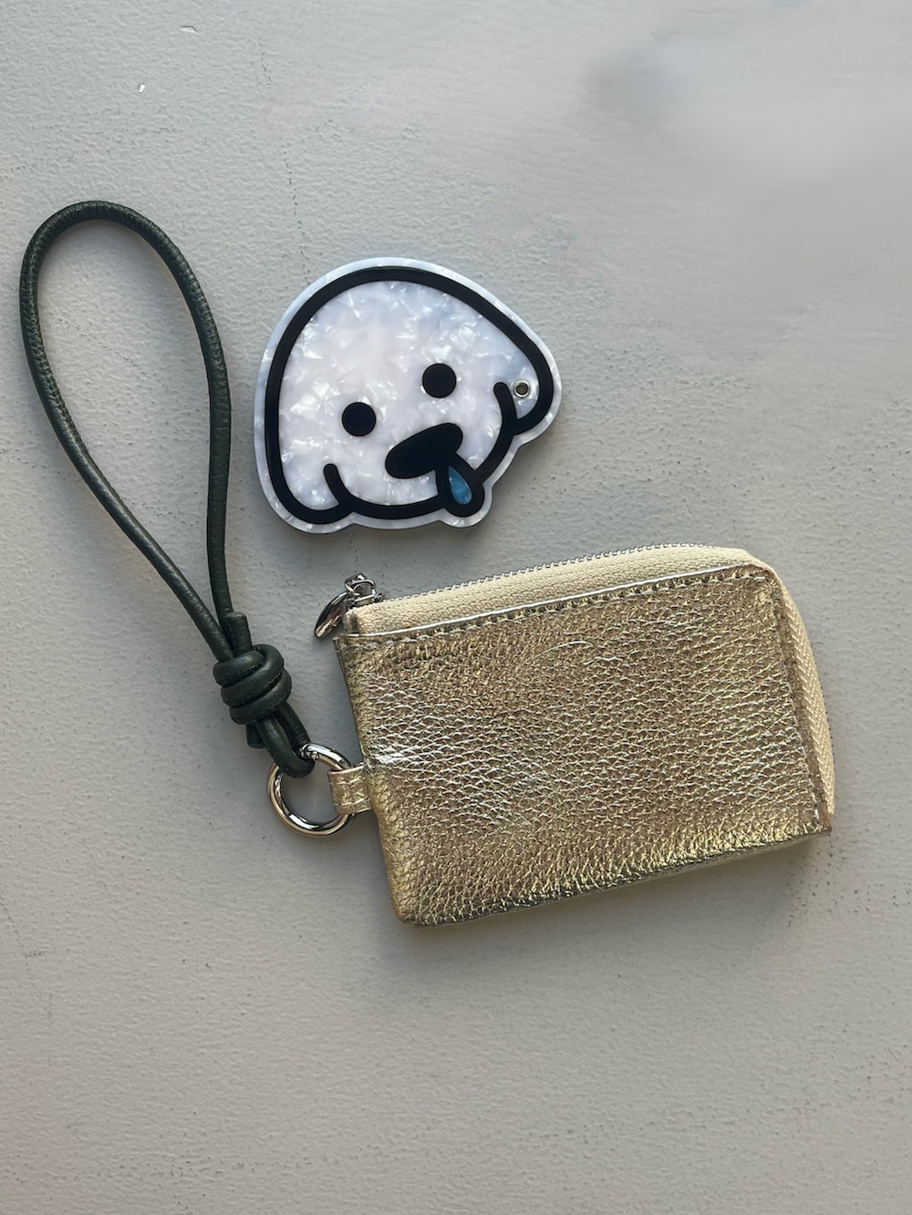 オレンジ系のキーホルダー、ベージュ系の財布、ピンク系のヘアオイル/ヘアミルクを着用したレディースの春コーディネートの2枚目の写真