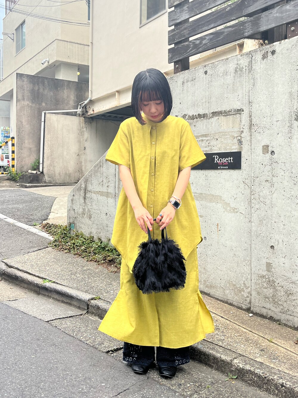 ブラック系のドレスシューズ、ブラック系のトートバッグ、イエロー系のワンピース/ドレスを着用したレディースの夏コーディネートの2枚目の写真