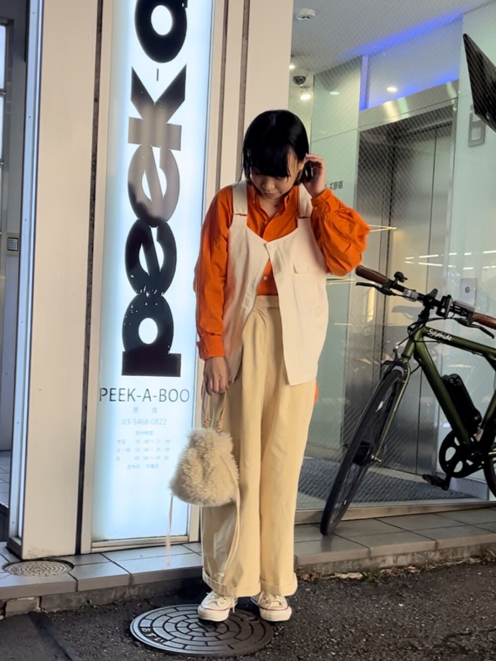 ホワイト系のトートバッグ、ホワイト系のスニーカー、ホワイト系のベストを着用したレディースの秋コーディネートの2枚目の写真