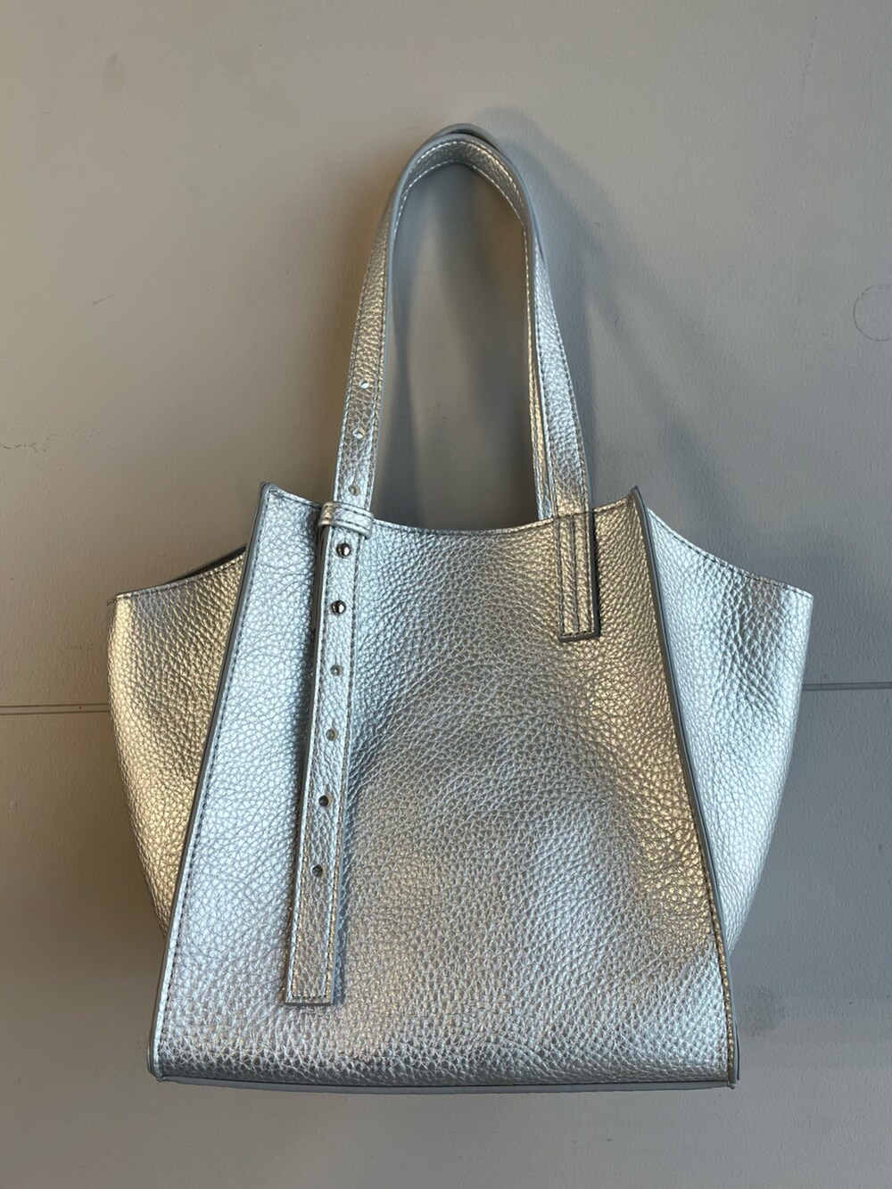 シルバー系のトートバッグ、ブラック系のTシャツ/カットソー、ブラック系のジャンパースカートを着用したレディースの冬コーディネートの4枚目の写真