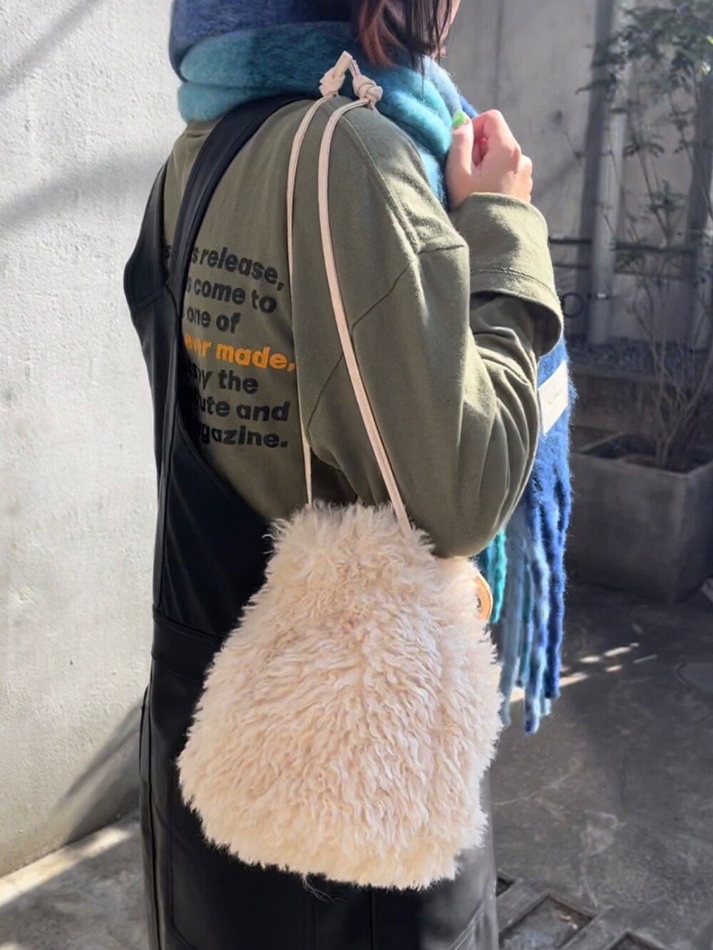 ホワイト系のトートバッグ、ブラック系のローファー、ブルー系のストール/ショールを着用したレディースの秋コーディネートの4枚目の写真