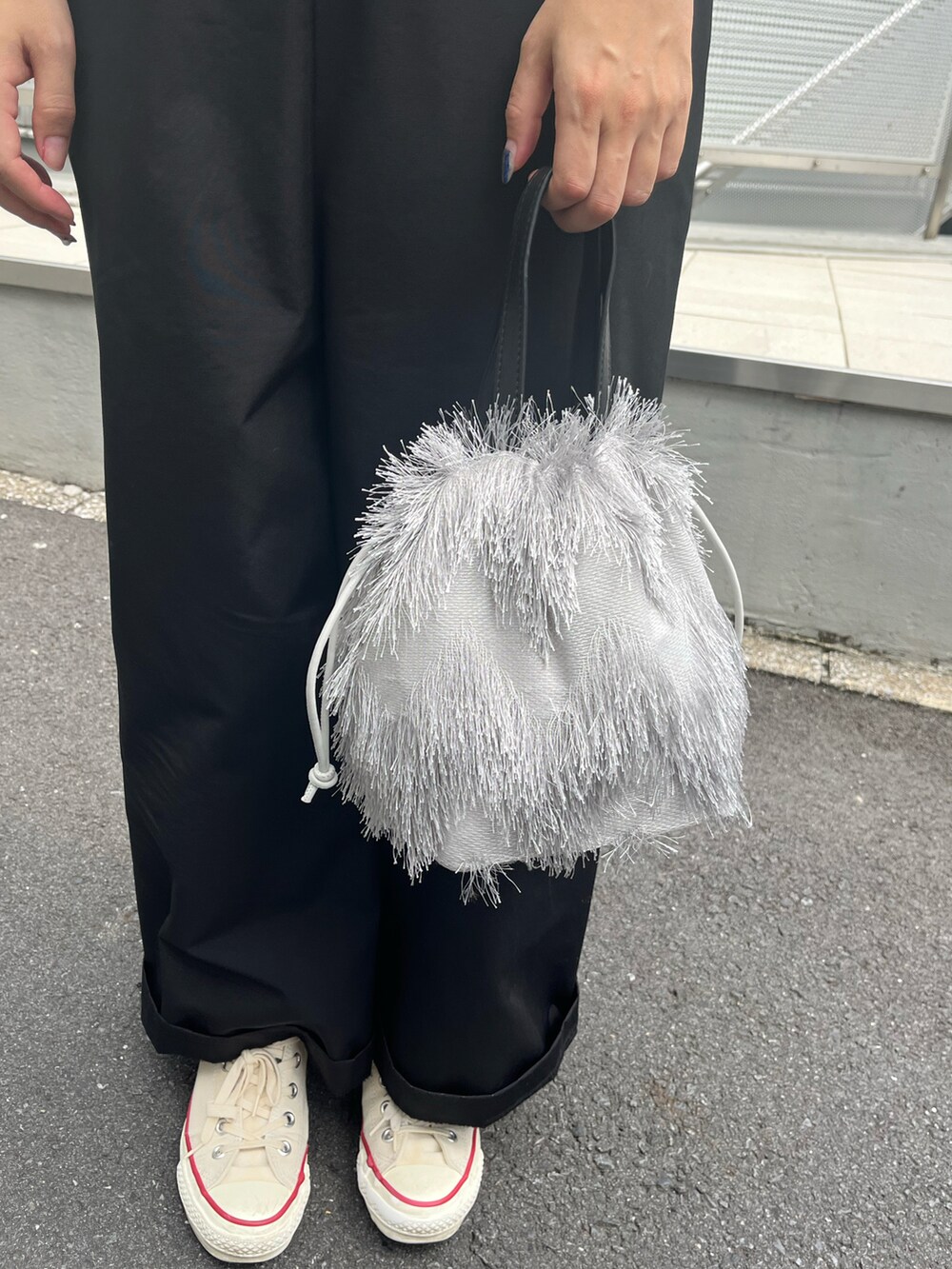 グレー系のトートバッグ、ホワイト系のスニーカー、ブラック系のハットを着用したレディースの夏コーディネートの2枚目の写真