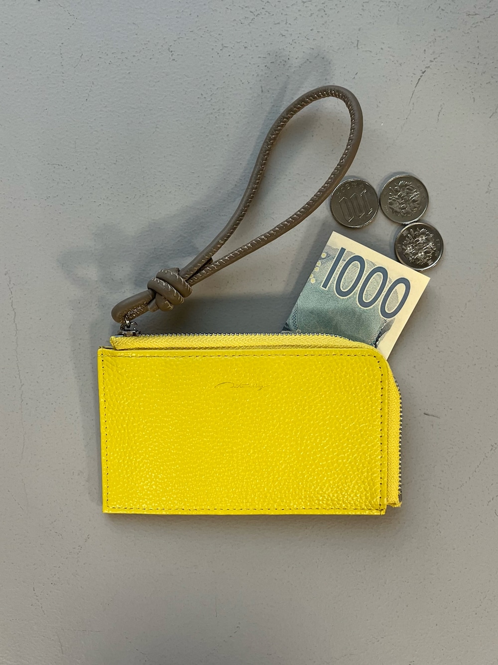 イエロー系の財布、ブラック系の水筒、オレンジ系の生活家電を着用したレディースの秋コーディネートの3枚目の写真