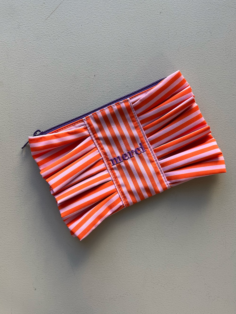 イエロー系のポーチ、シルバー系の財布、ピンク系のポーチを着用したレディースの春コーディネートの5枚目の写真