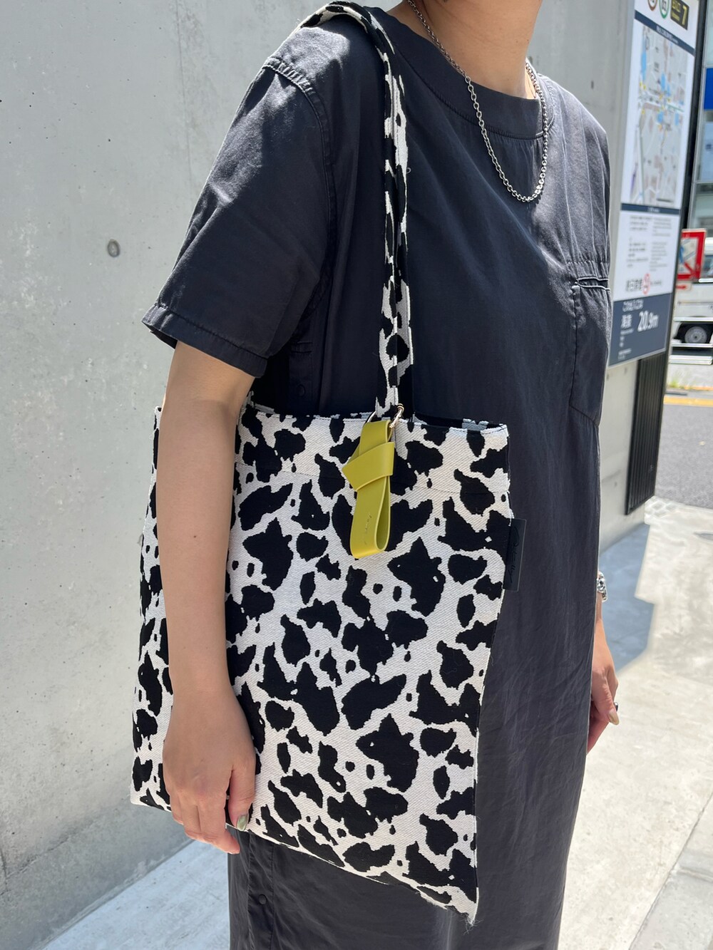 ホワイト系のトートバッグ、ブラック系のワンピース、ブラック系のドレスシューズを着用したレディースの夏コーディネートの2枚目の写真