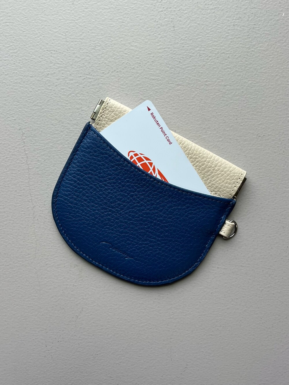 グリーン系のスマホグッズ、シルバー系のポーチ、ホワイト系のその他小物を着用したレディースの秋コーディネートの3枚目の写真