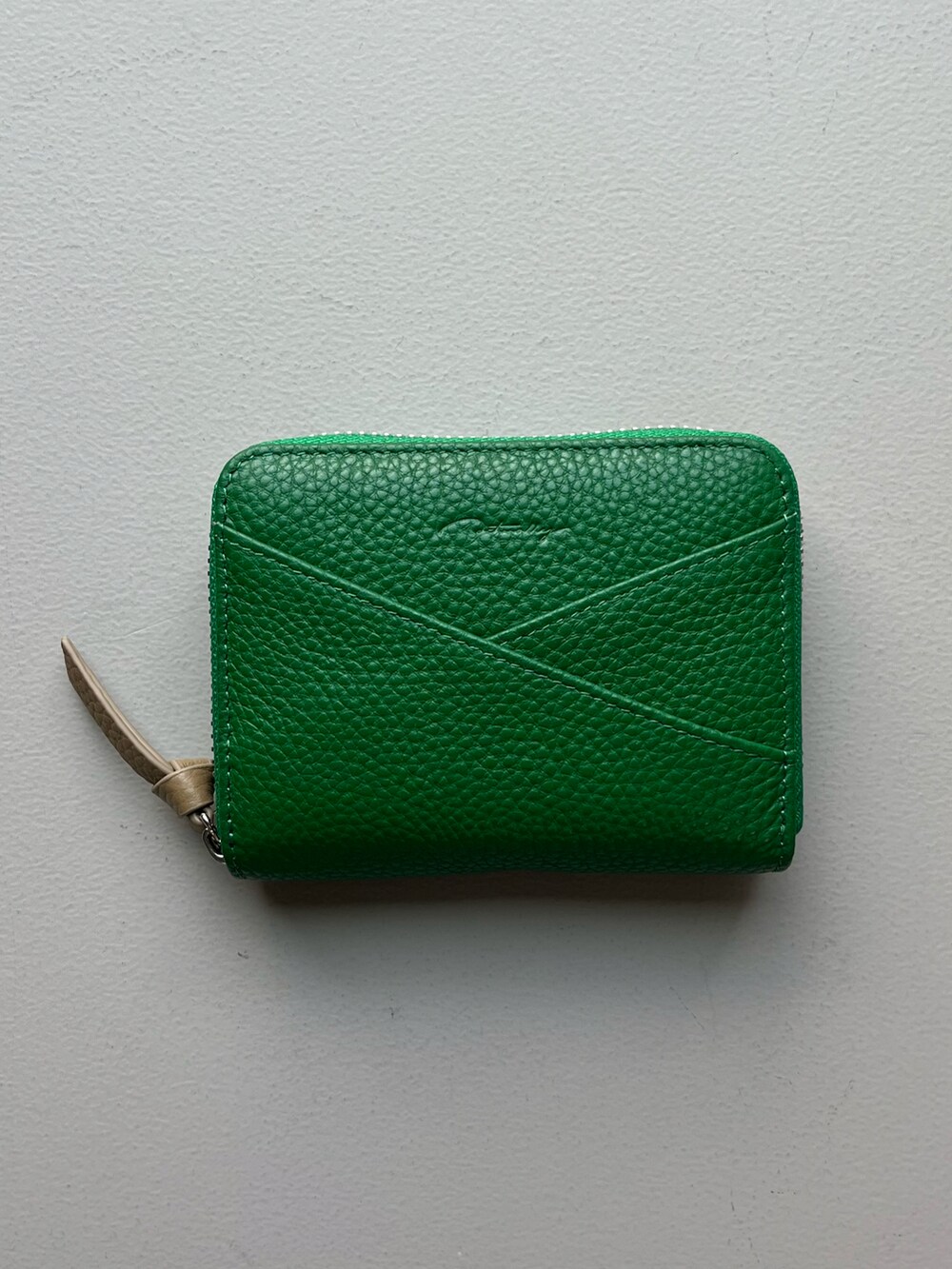 グリーン系の財布、ブルー系のポーチ、シルバー系のチャームを着用したレディースの夏コーディネートの4枚目の写真