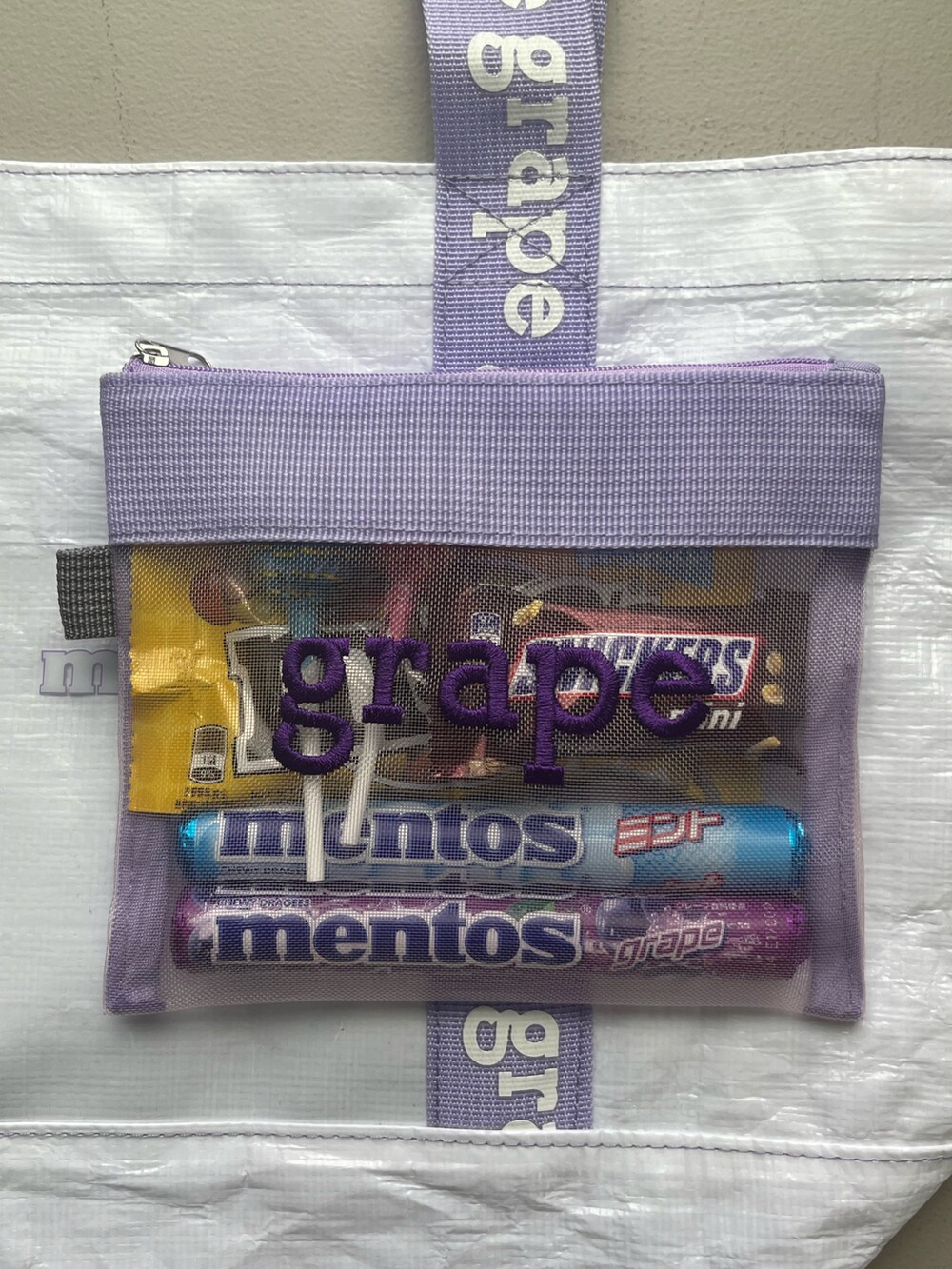 パープル系のトートバッグ、パープル系のポーチを着用したレディースの夏コーディネートの2枚目の写真