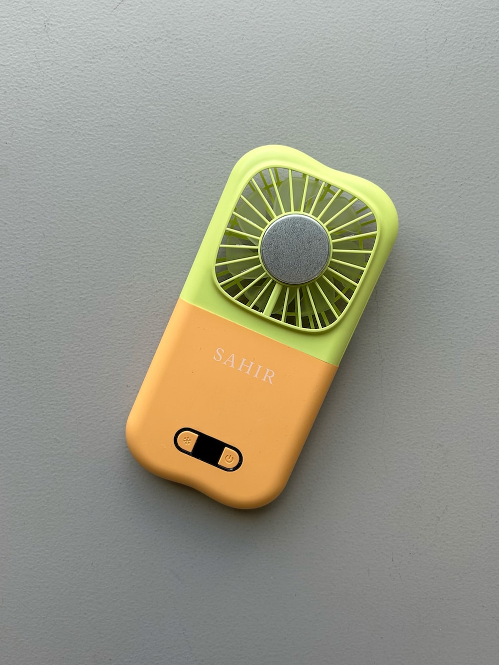 オレンジ系のポーチ、ホワイト系のチャーム、グレー系のポーチを着用したレディースの春コーディネートの3枚目の写真