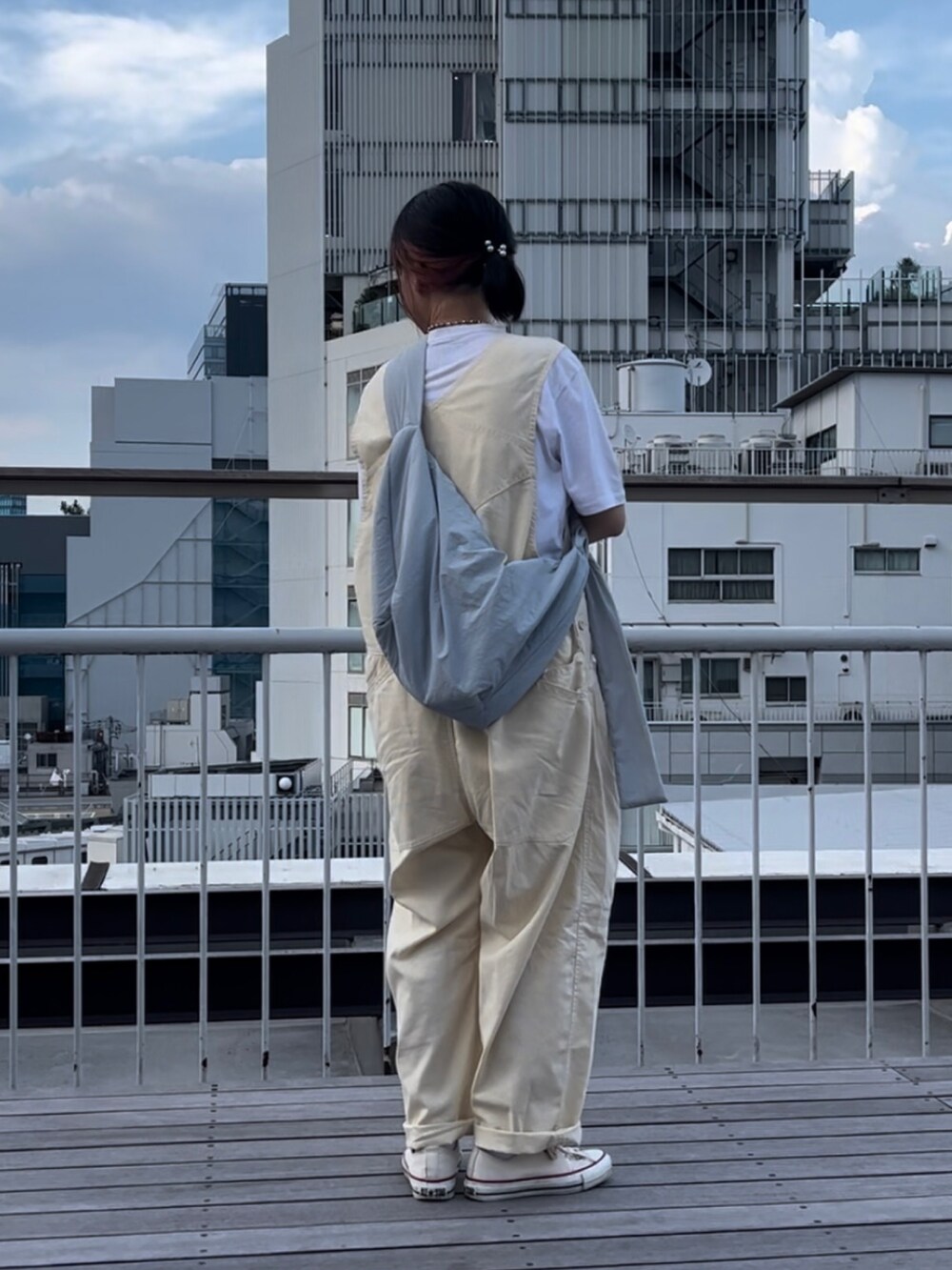 ベージュ系のオールインワン・サロペット、ホワイト系のスニーカー、ブルー系のショルダーバッグを着用したレディースの夏コーディネートの2枚目の写真