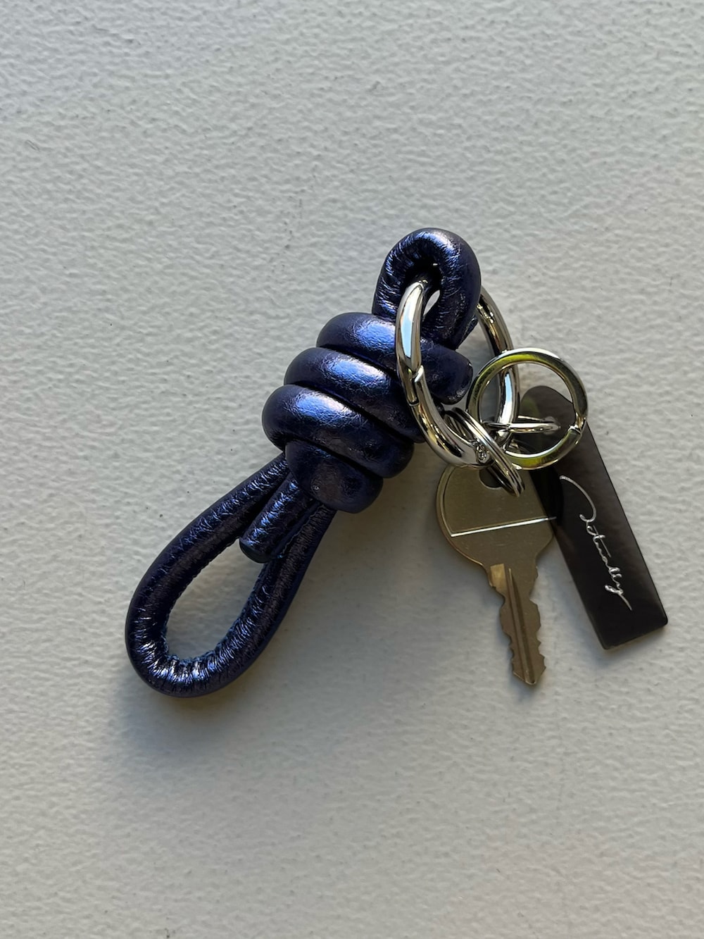 シルバー系の財布、ホワイト系の香水、ブルー系のチャームを着用したレディースの冬コーディネートの5枚目の写真