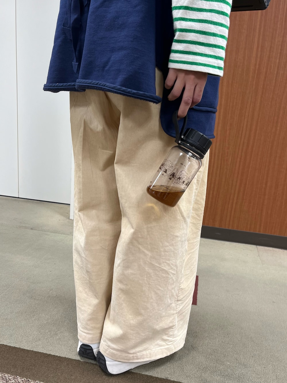 グリーン系の財布、ブラック系のポーチ、ブラック系の水筒を着用したレディースの秋コーディネートの5枚目の写真