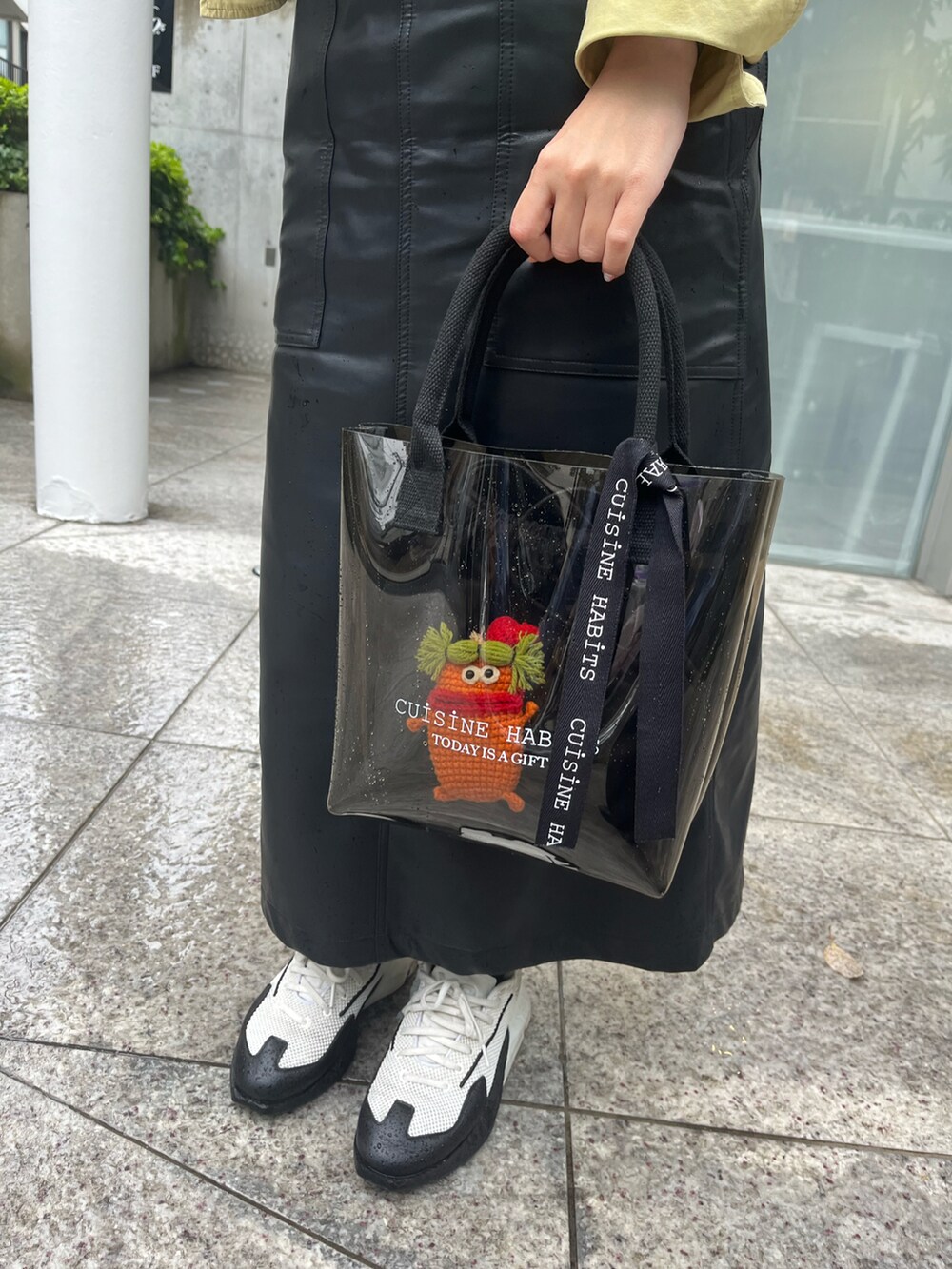 ホワイト系のスニーカー、ブラック系のジャンパースカート、グリーン系のシャツ/ブラウスを着用したレディースの春コーディネートの2枚目の写真