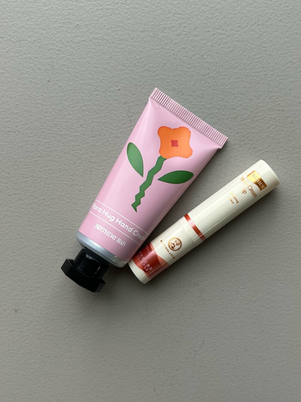 オレンジ系のポーチ、ゴールド系のパスケース、ブルー系のチャームを着用したレディースの春コーディネートの4枚目の写真