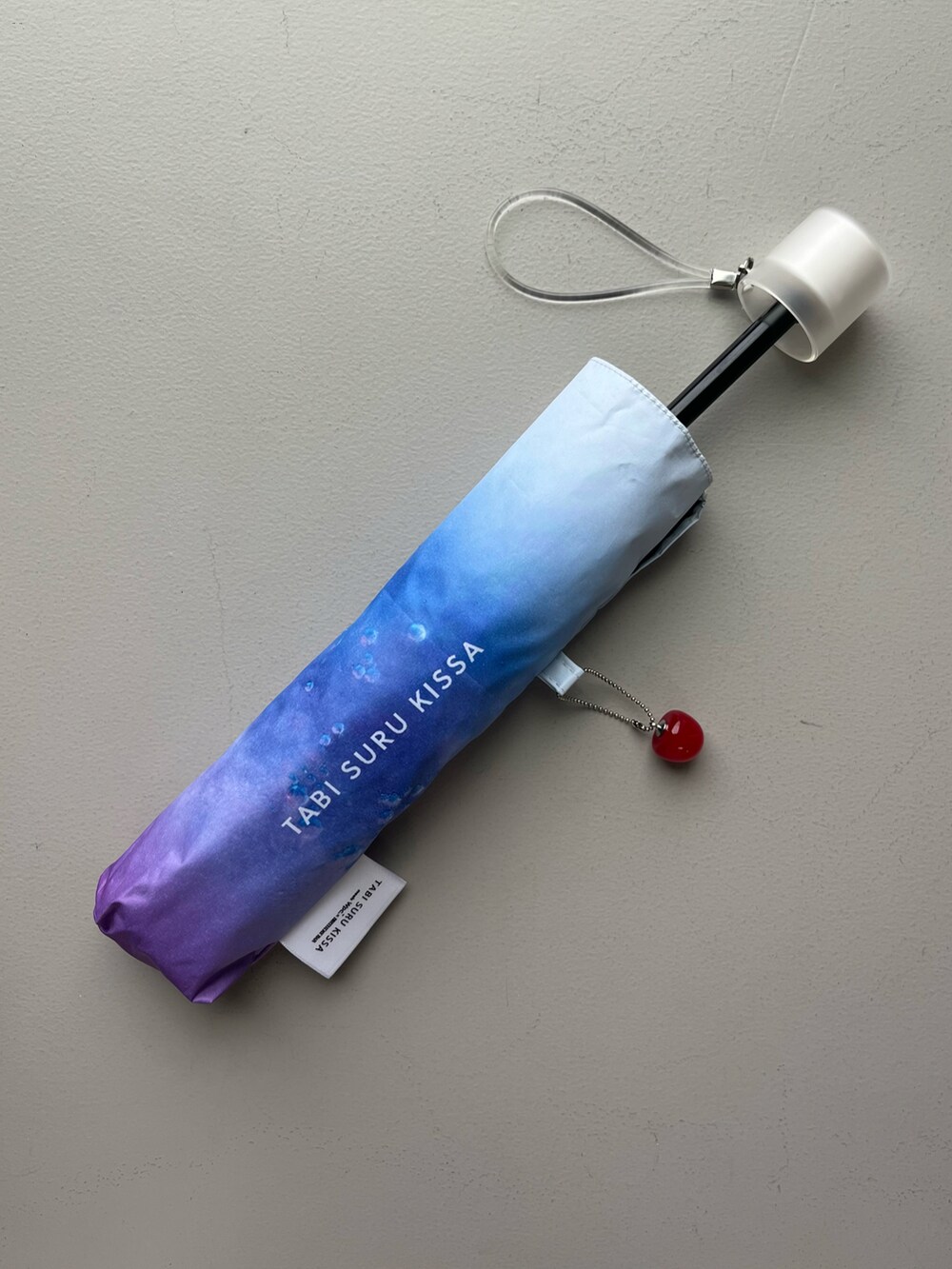 ブルー系のTシャツ/カットソー、ピンク系のトートバッグ、パープル系の折りたたみ傘を着用したレディースの夏コーディネートの5枚目の写真