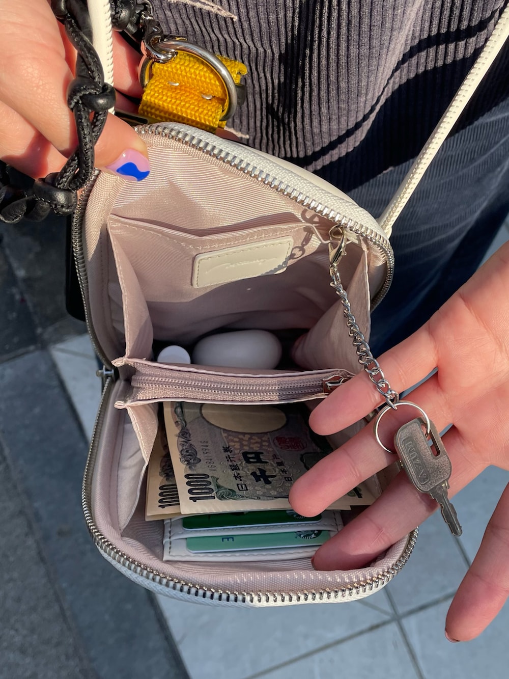 ホワイト系のショルダーバッグ、ブラック系のトップス、ブラック系のサロペット/オーバーオールを着用したレディースの冬コーディネートの4枚目の写真