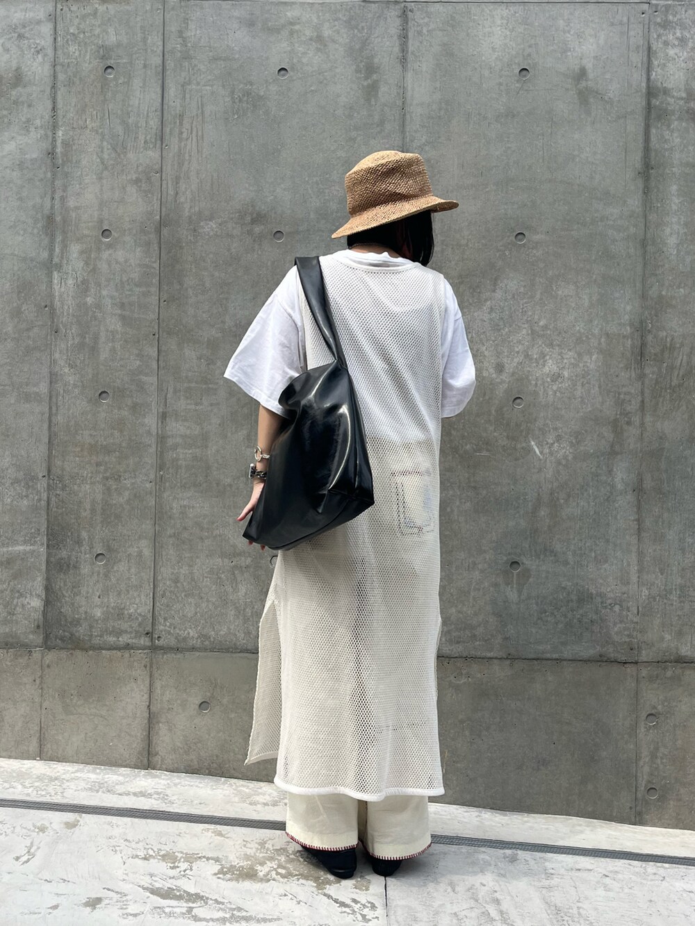 ブラック系のトートバッグ、ホワイト系のその他パンツ、ブラック系のドレスシューズを着用したレディースの夏コーディネートの2枚目の写真