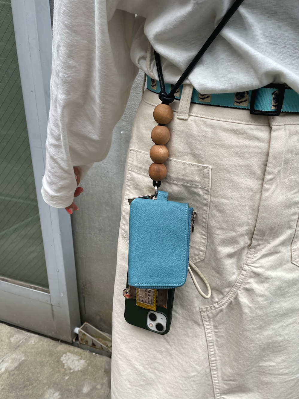 ホワイト系のスニーカー、ベージュ系のスカート、ブラック系のトートバッグを着用したレディースの春コーディネートの3枚目の写真