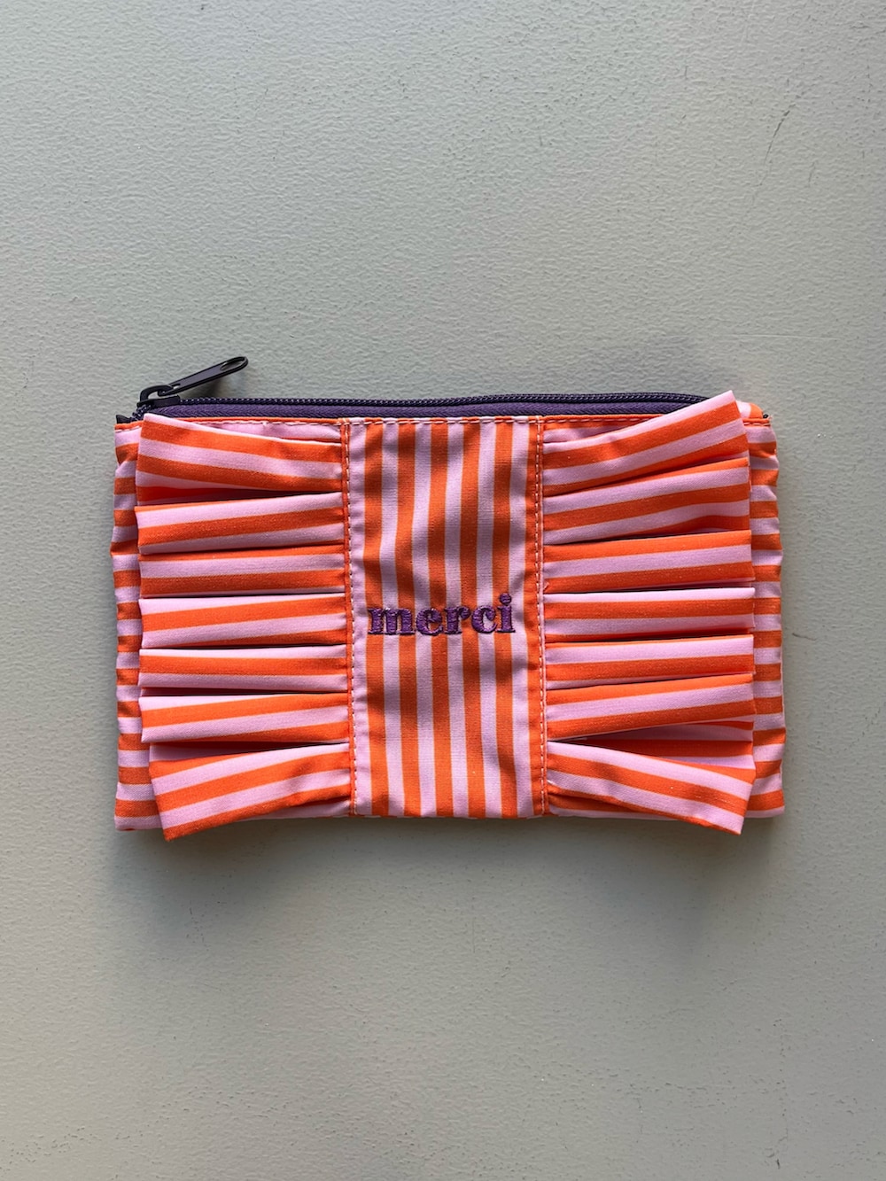 ピンク系のポーチ、イエロー系のパスケース、グリーン系のハンドケア/ハンドクリームを着用したレディースの春コーディネートの2枚目の写真