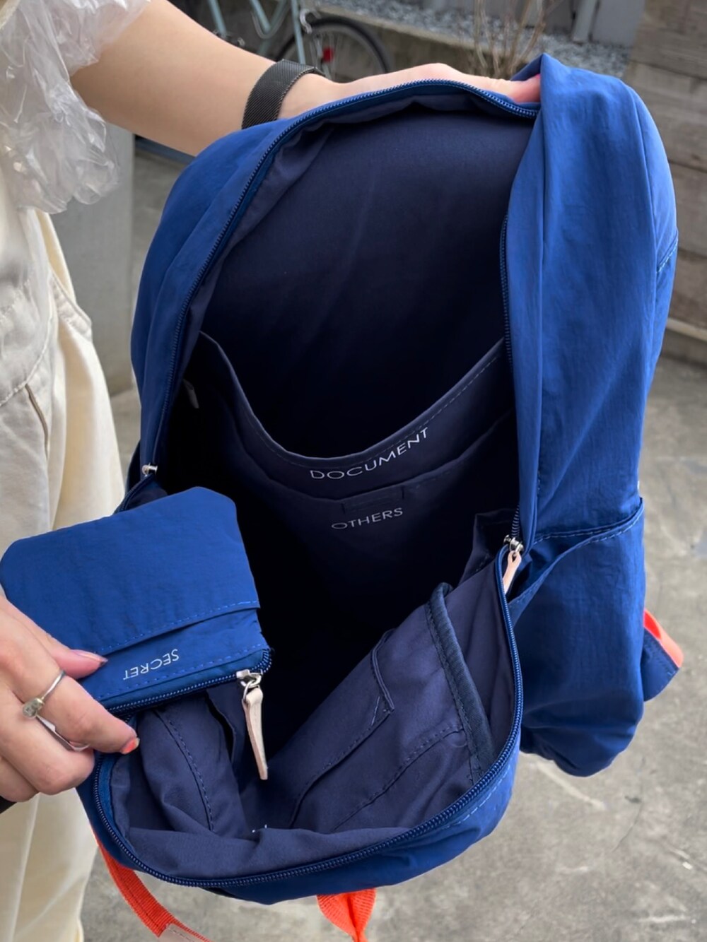 ブルー系のバックパック/リュック、ホワイト系のスニーカー、ベージュ系のサロペット/オーバーオールを着用したレディースの夏コーディネートの3枚目の写真