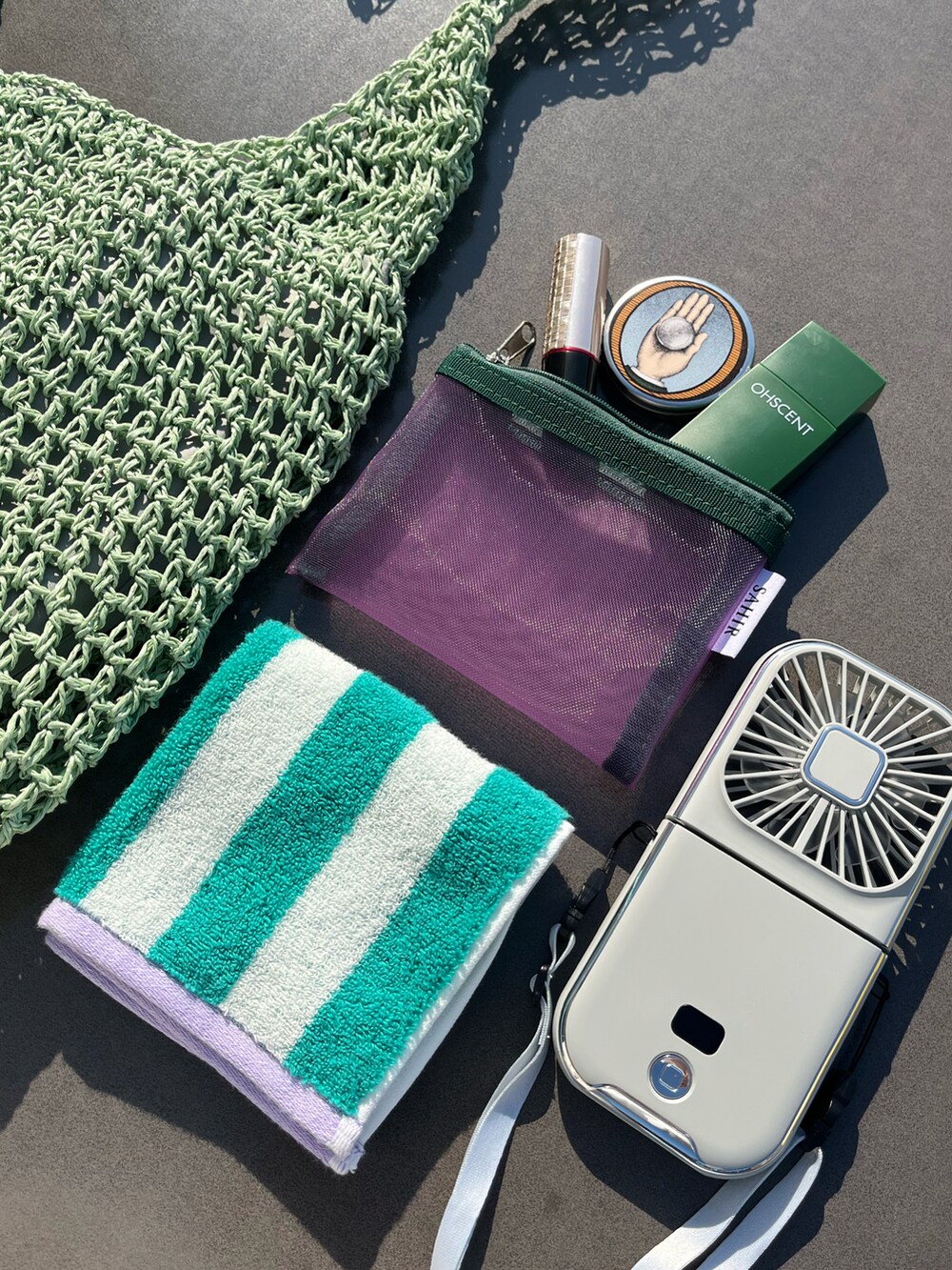 グリーン系のショルダーバッグ、グリーン系のハンカチ/ハンドタオル、ピンク系のポーチを着用したレディースの夏コーディネートの2枚目の写真