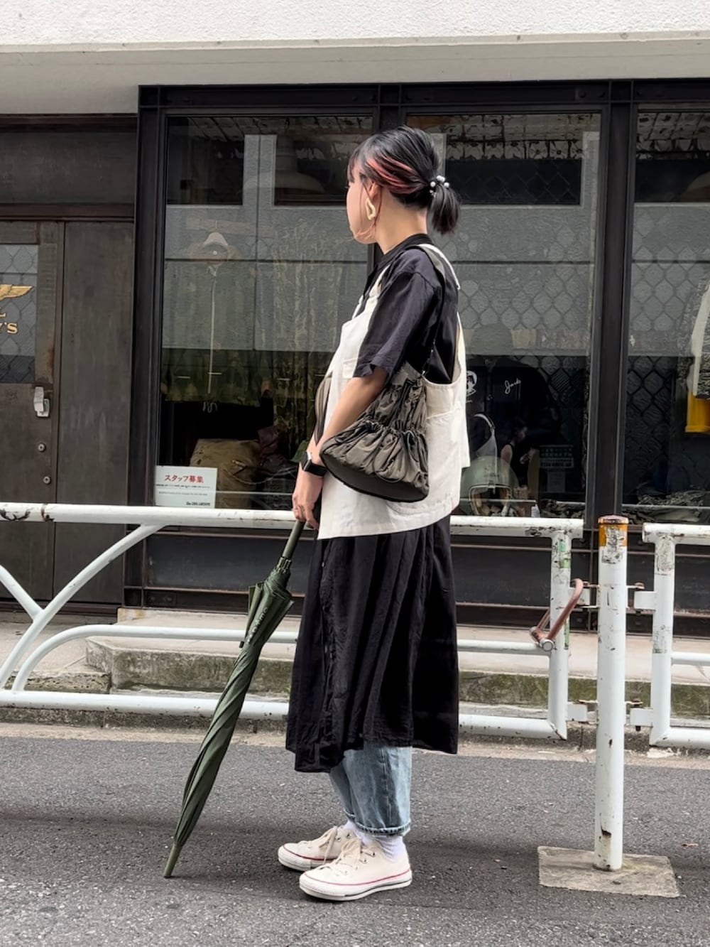 グリーン系のトートバッグ、ホワイト系のスニーカー、ホワイト系のベストを着用したレディースの夏コーディネートの2枚目の写真