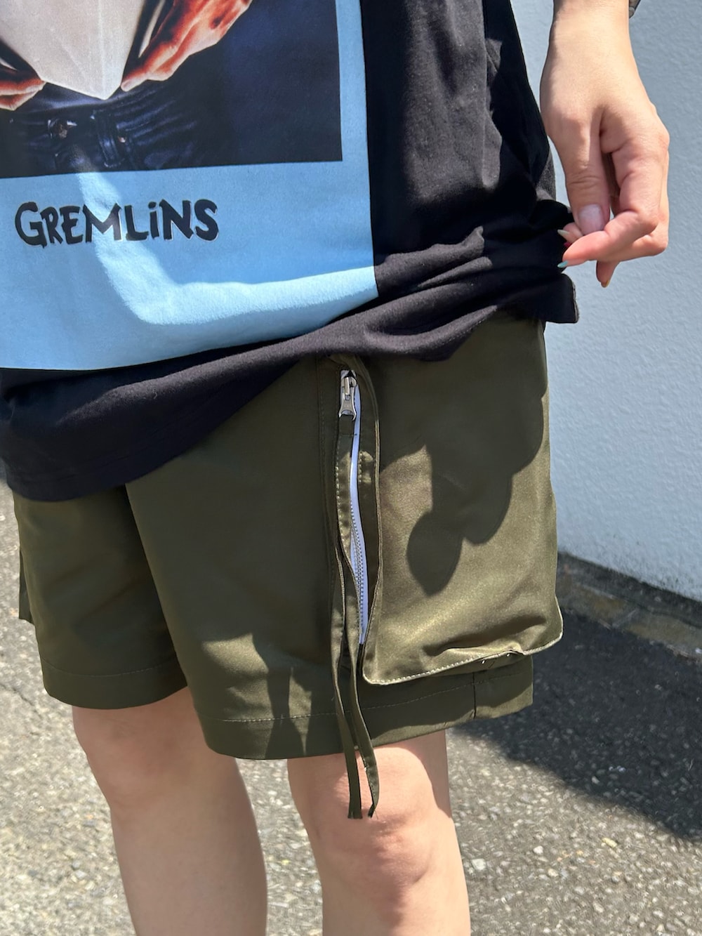 ブラック系のTシャツ/カットソー、グリーン系のその他パンツ、ホワイト系のスニーカーを着用したレディースの夏コーディネートの4枚目の写真