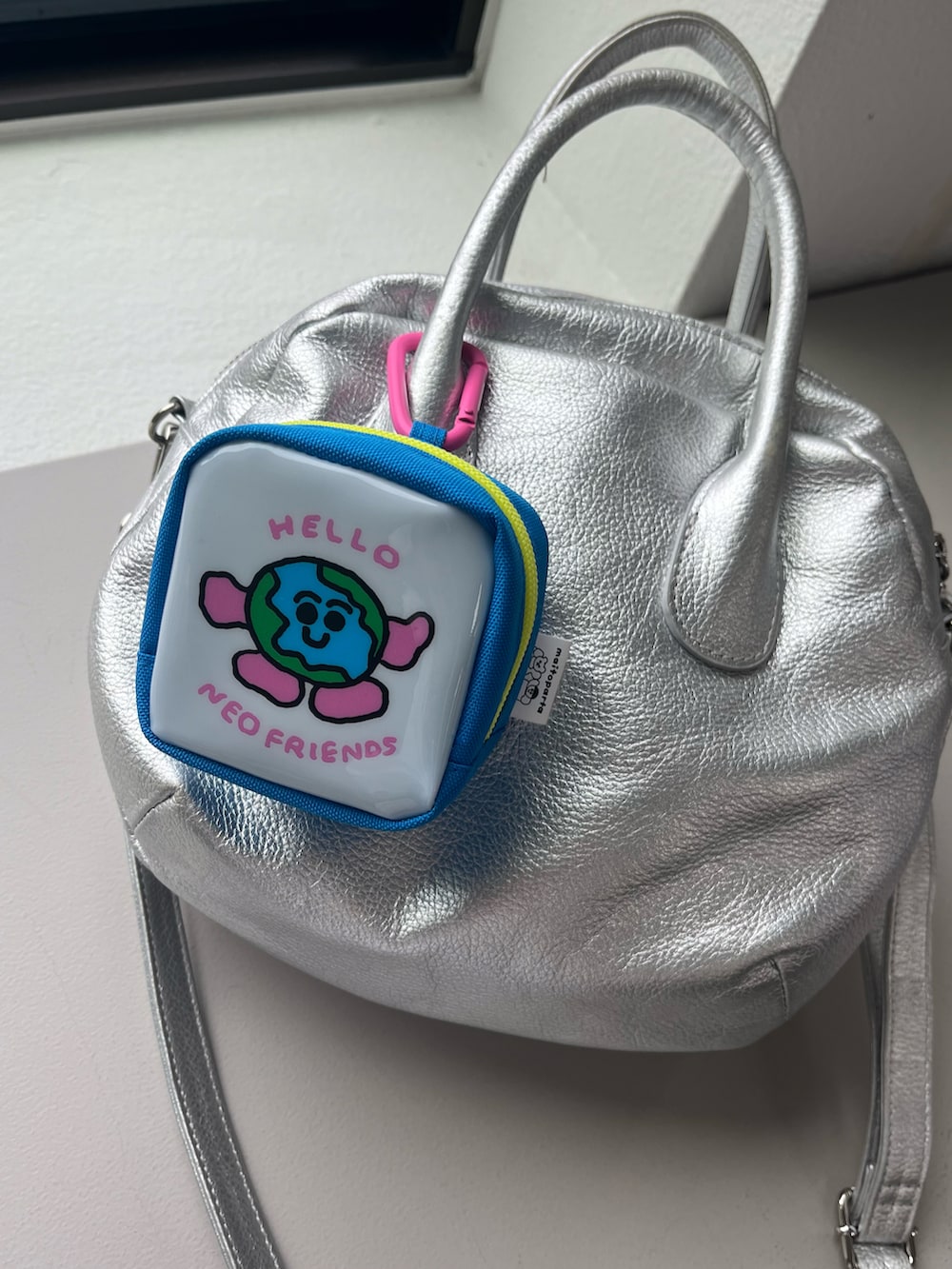 シルバー系の財布、ピンク系のポーチ、ホワイト系の香水を着用したレディースの夏コーディネートの4枚目の写真