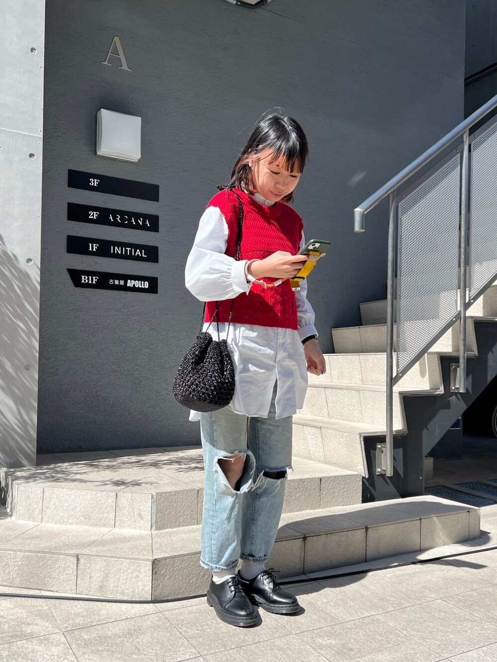 ブラック系のショルダーバッグ、ブラック系のローファー、ホワイト系のシャツ/ブラウスを着用したレディースの春コーディネートの2枚目の写真