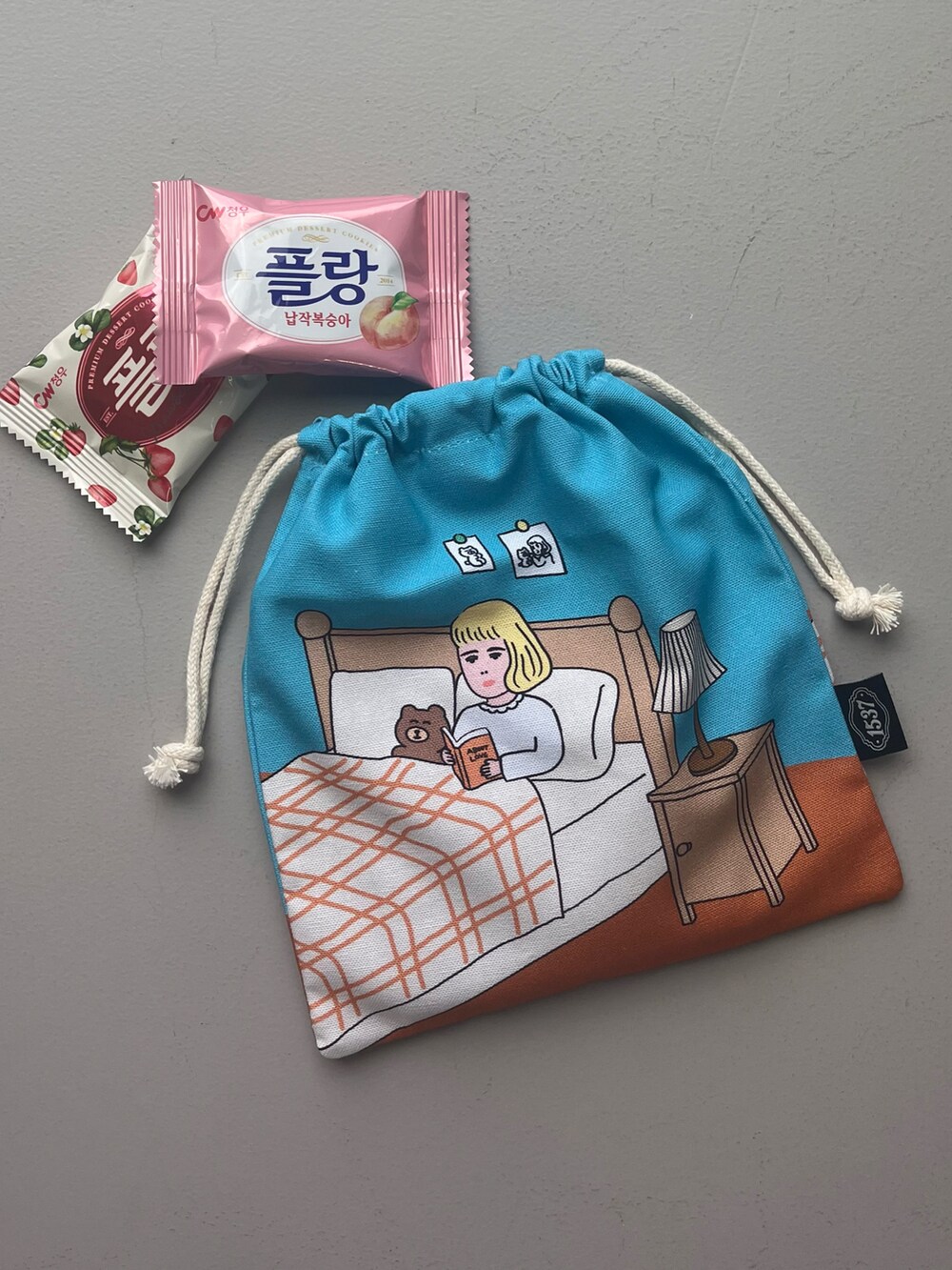 ピンク系のエコバッグ/サブバッグ、グリーン系のポーチ、ベージュ系のチャームを着用したレディースの夏コーディネートの2枚目の写真