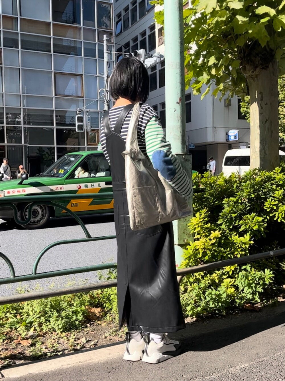 ゴールド系のトートバッグ、ホワイト系のスニーカー、その他のTシャツ/カットソーを着用したレディースの秋コーディネートの2枚目の写真