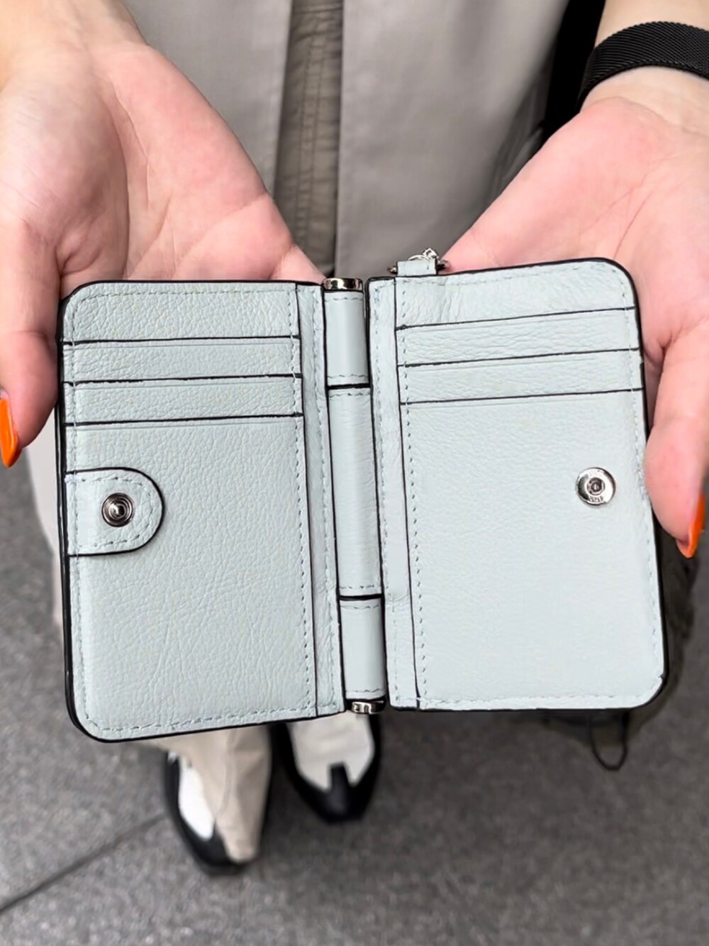 グリーン系のトートバッグ、ホワイト系のスニーカー、ブルー系の財布を着用したレディースの夏コーディネートの3枚目の写真