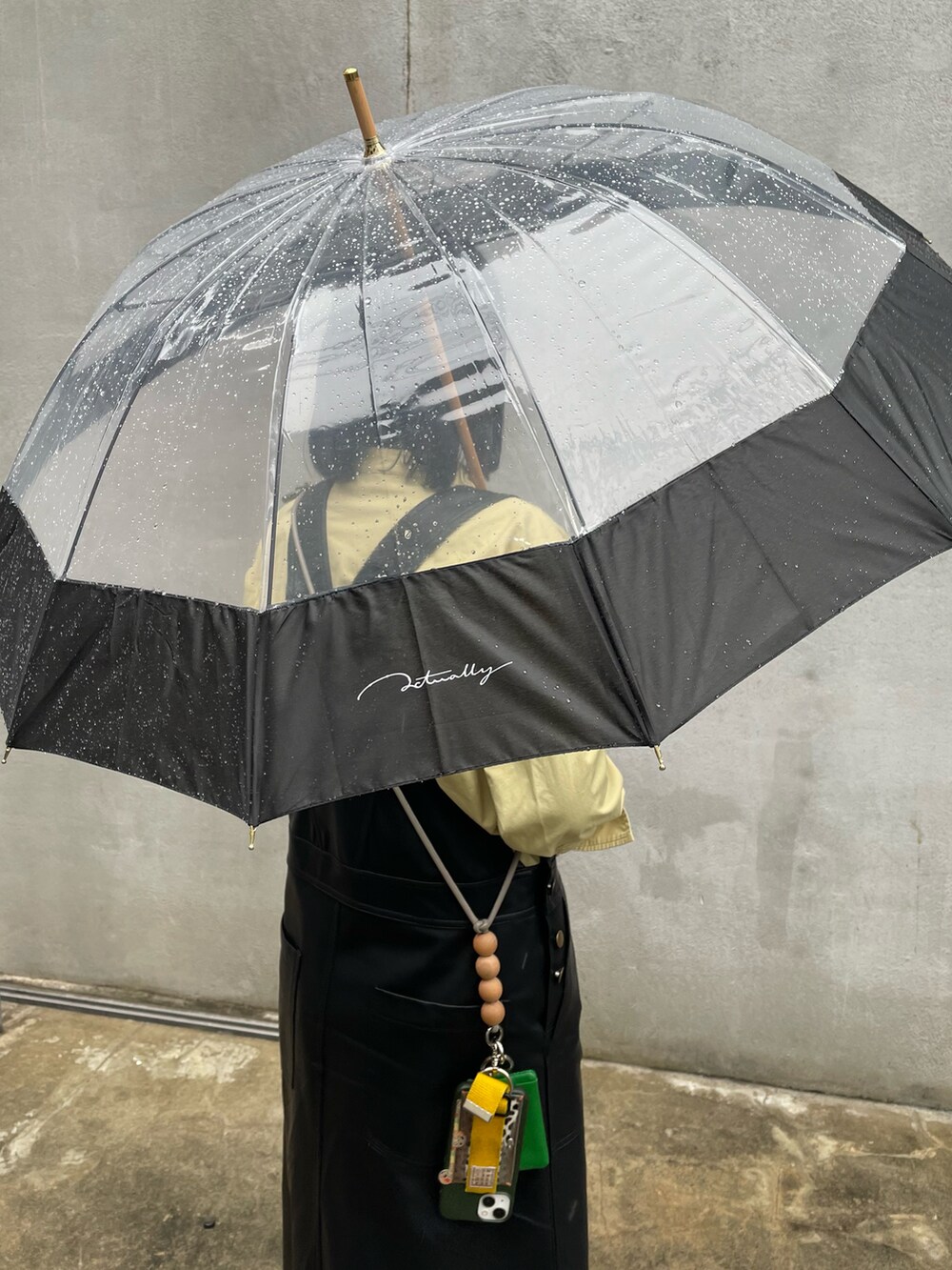 ホワイト系のスニーカー、ブラック系のジャンパースカート、グリーン系のシャツ/ブラウスを着用したレディースの春コーディネートの2枚目の写真