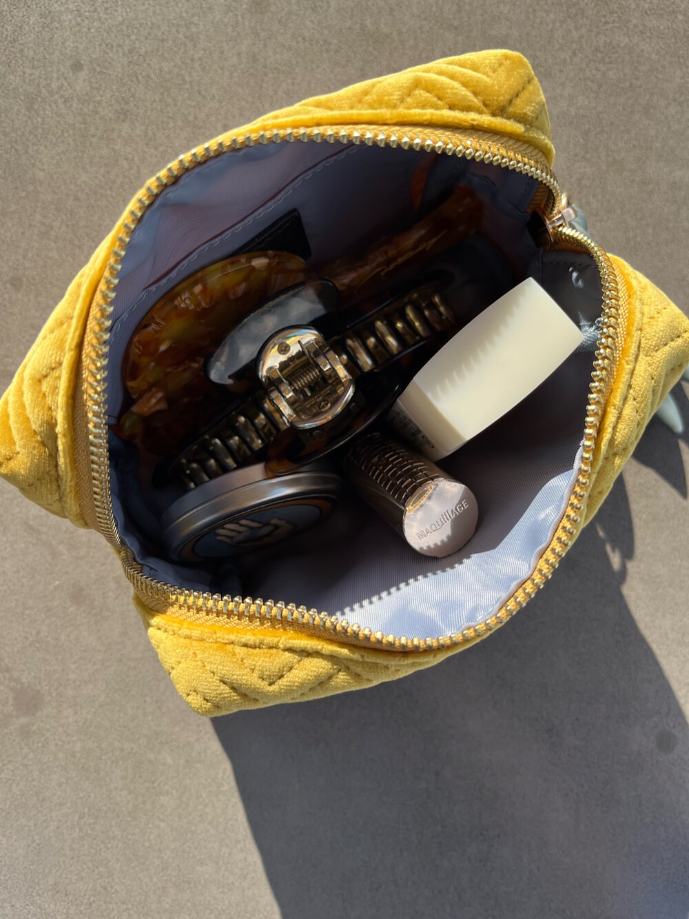 シルバー系のパスケース、イエロー系のヘアブラシ、イエロー系のボディケア/ボディクリームを着用したレディースの夏コーディネートの2枚目の写真