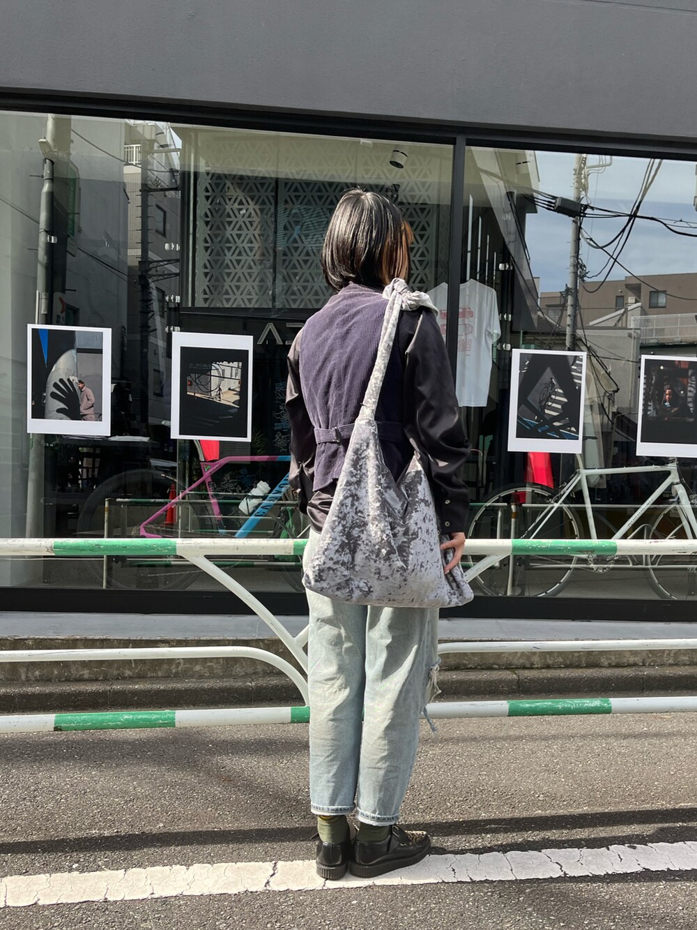 グレー系のトートバッグ、ブルー系のデニムパンツ、グリーン系のソックス/靴下を着用したレディースの秋コーディネートの2枚目の写真