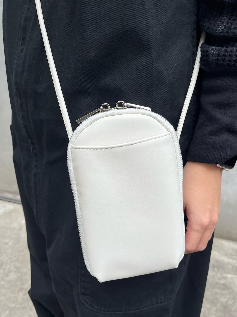 ホワイト系のショルダーバッグ、ブラック系のトップス、ブラック系のサロペット/オーバーオールを着用したレディースの冬コーディネートの3枚目の写真